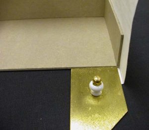 Brass triangle used to make a recessed cut of the cloth on the A tray