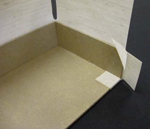 First cloth flap glued down on floor of A tray at open corner