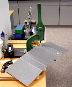 The top rivet piece, then the washer, then the board, then the bottom rivet piece are put in place.
