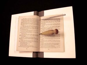 Pamphlet with sewing holes being punched with awls