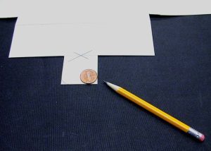 Penny being used to mark where to cut to round the flap's corners