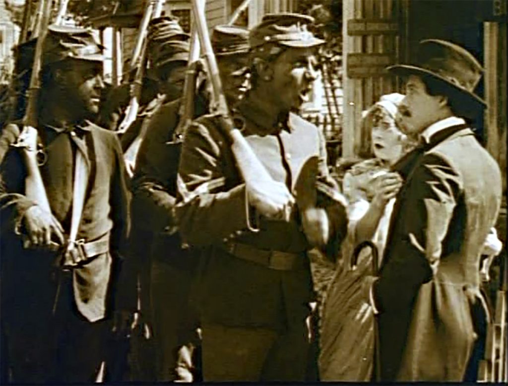 The US militia takes over the sidewalks of Piedmont, pushing away the Camerons in front of their own house (screen capture by author).