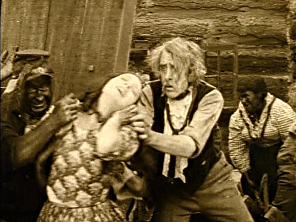 Phil Stoneman barricades the door with his body and Dr. Cameron saves his last shot to kill his daughter rather than let her be raped. Visually and narratively, the cabin is a visual metaphor for the besieged white vagina (screen capture by author).