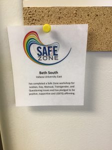 Image of Safe Zone door sticker. Sticker says Safe Zone, participants name, and the disclosure that the participant has completed a Safe Zone workshop and has pledged to be positive, supportive, and LGBTQ-affirming.