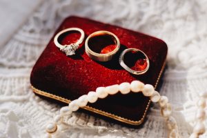 Three engagement rings sit on a pillow