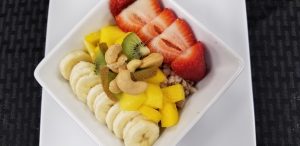 Whole grain farro with banana, mango, strawberries, and a cashew nut garnish