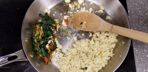 cooking tofu and vegetables in a stainless steel pan