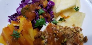 cabbage, pistachio crusted white fish, pineapple, yellow peppers and spicy peach dressing in a bowl