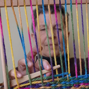 Dr. Anne Allen weaves on a Navajo loom.